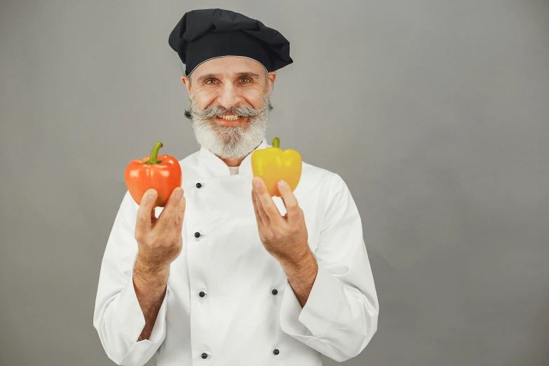 a man in a chef's hat holding two peppers, pexels contest winner, short white beard, model posing, precision, multicoloured