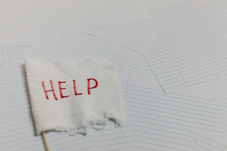 a piece of paper with the word help written on it, pexels, happening, tattered fabric, background image, schools, suicide