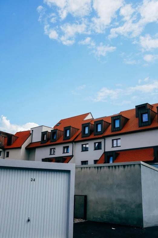 a couple of buildings that are next to each other, unsplash, bauhaus, orange roof, low quality photo, simple gable roofs, 4 k ”