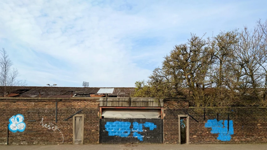 a red fire hydrant sitting in front of a brick wall, an album cover, by Daarken, graffiti, blue skies, abandoned car garage, background image, hannover