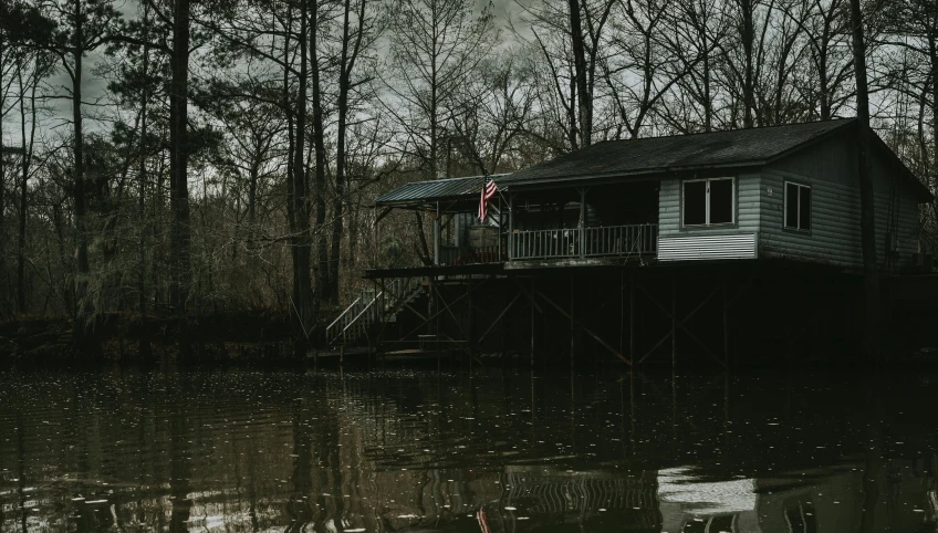 a house sitting on top of a body of water, by Carey Morris, pexels contest winner, redneck, slight overcast, southern gothic, album cover