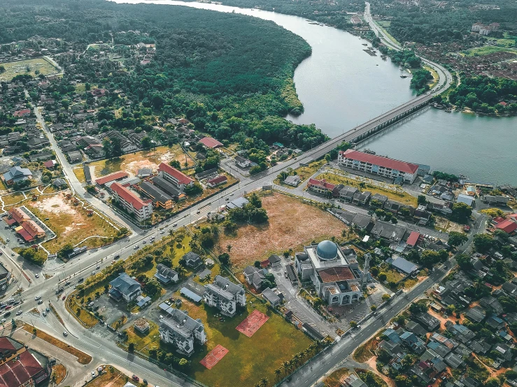 an aerial view of a residential area next to a river, by Marshall Arisman, pexels contest winner, photorealism, mixed development, shipibo, panorama view, ((oversaturated))