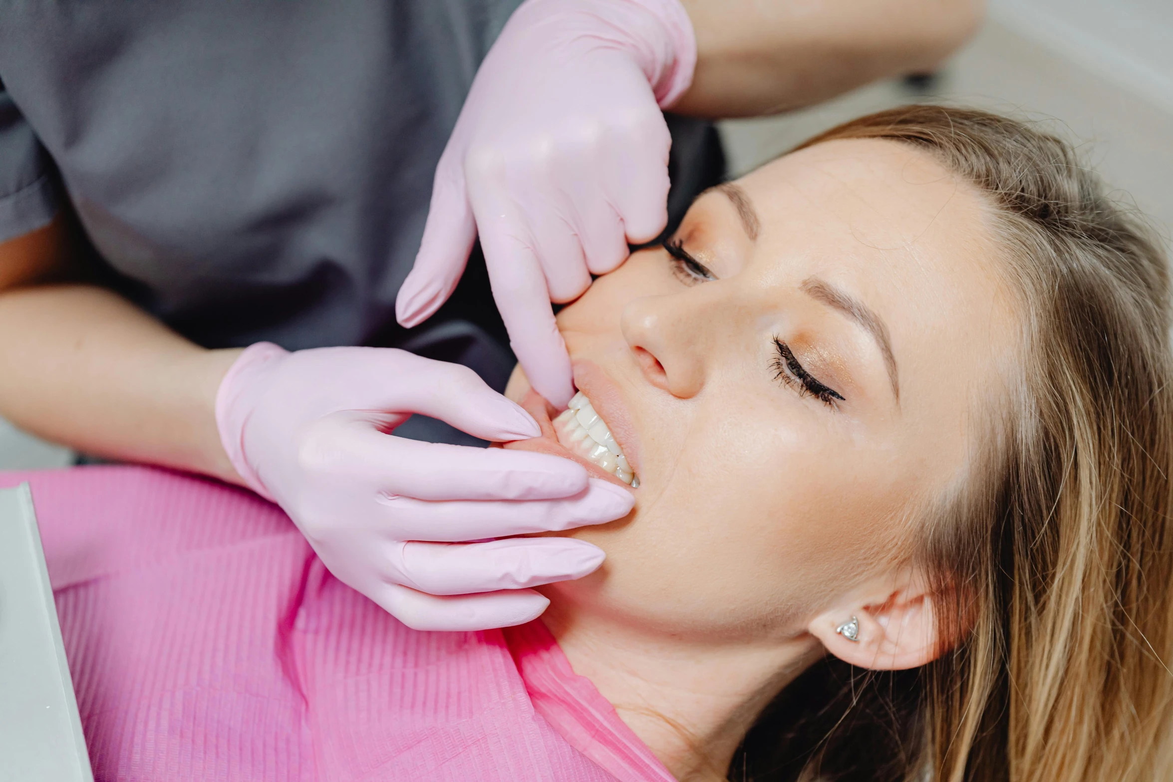 a woman getting her teeth examined by a dentist, by Lee Loughridge, pexels contest winner, romanticism, straight jawline, lying down, half image, square jaw-line