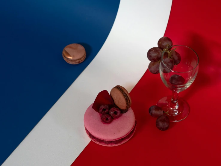 a dessert sitting on top of a red white and blue table, a still life, inspired by François Louis Thomas Francia, trending on unsplash, photorealism, magenta colours, macaron, union jack, portrait 4 / 3