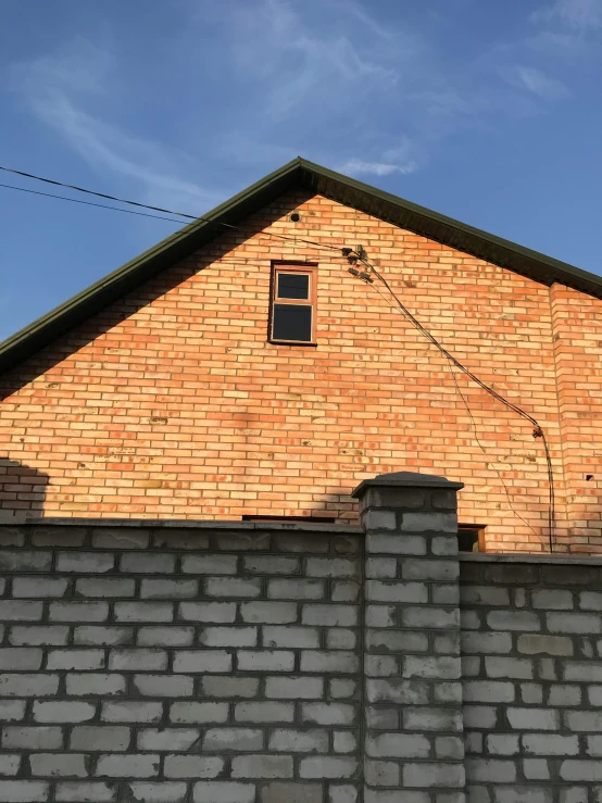 a red fire hydrant sitting in front of a brick building, a picture, by Attila Meszlenyi, modernism, simple gable roofs, 8 k photo, barn, 35mm —w 1920 —h 1080