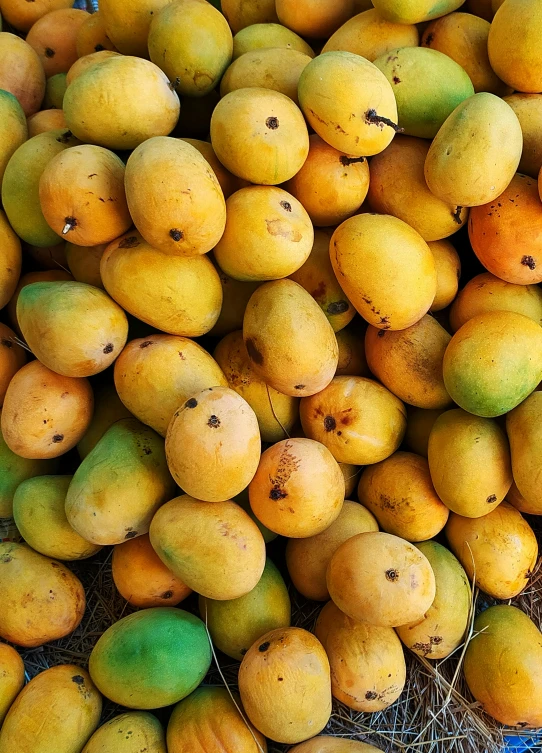 a pile of mangoes sitting on top of each other, zoomed in, various sizes, thumbnail, exterior shot