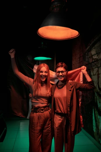 a man and a woman standing next to each other, antipodeans, holding up a night lamp, underground party, production photo, holding a shield