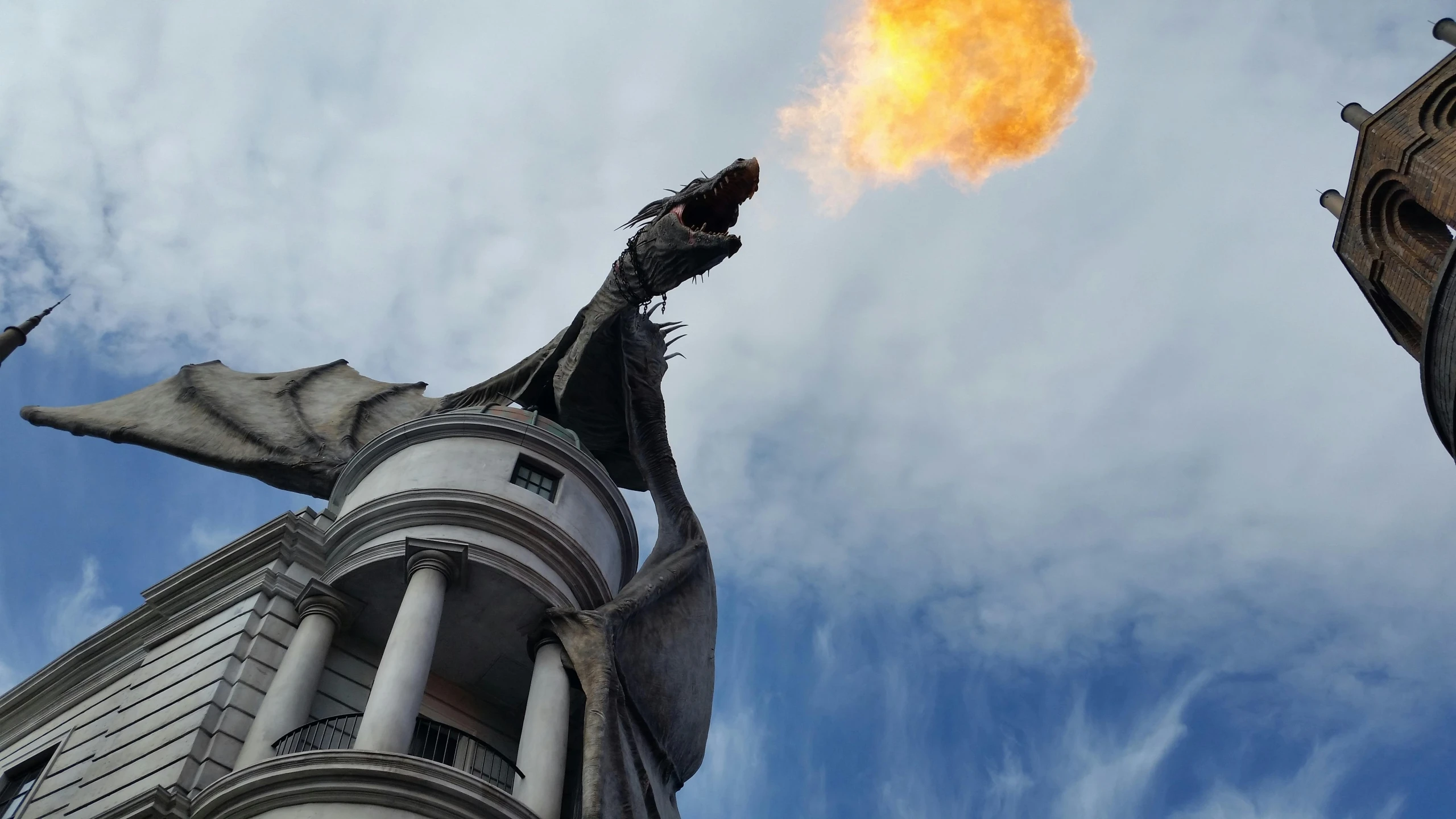 a close up of a building with a fire coming out of it, by Alejandro Obregón, pexels contest winner, art nouveau, a dragon made of clouds, magic kingdom, square, low angle view