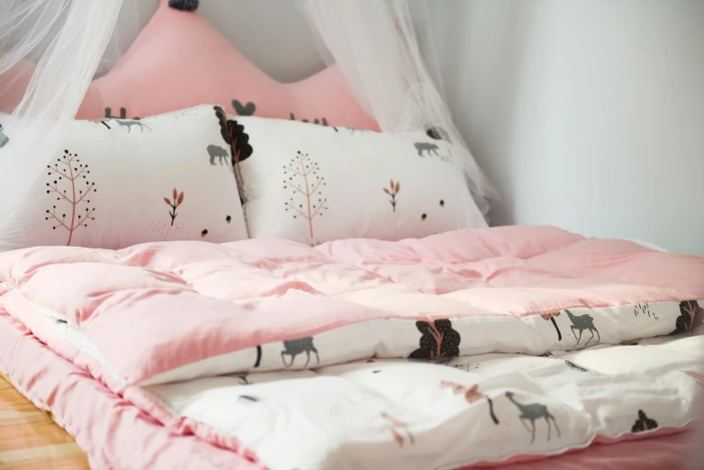 a bed with a mosquito net on top of it, inspired by Elsa Beskow, trending on unsplash, pink scheme, deer in sherwood forest, quilt, wearing a pastel pink hoodie