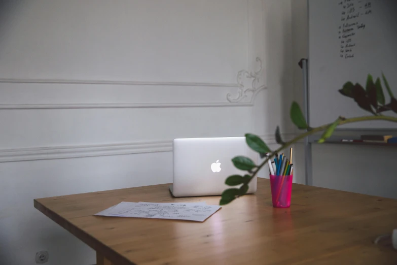 a laptop computer sitting on top of a wooden table, by Romain brook, pexels, postminimalism, sitting in french apartment, with apple, ornate designs on desk, white backround