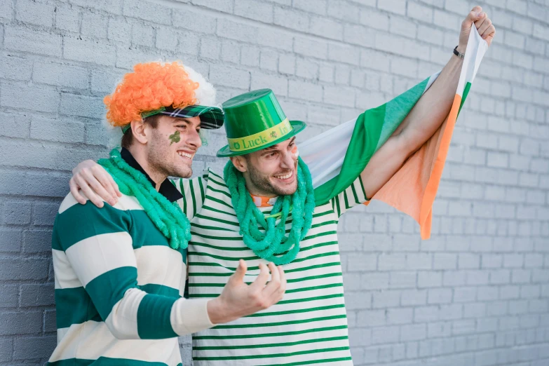 a couple of men standing next to each other, inspired by Mór Than, pexels contest winner, green flags, fancy dress, striped, beer