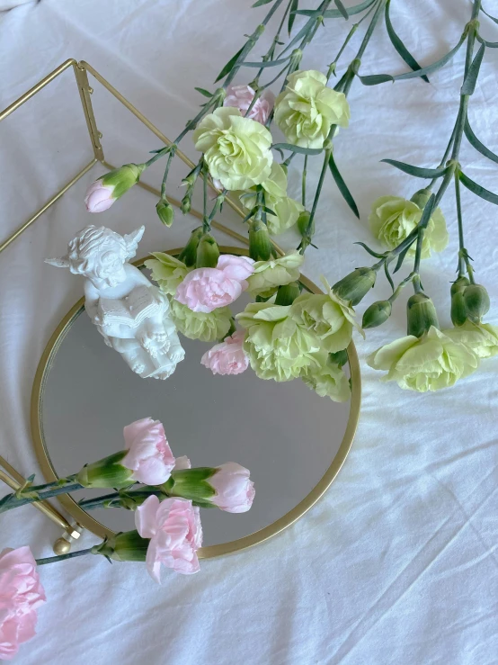 a mirror sitting on top of a table next to flowers, a marble sculpture, by Marie Angel, trending on unsplash, rococo, low quality photo, pink white and green, high angle close up shot, head made of carnations flower