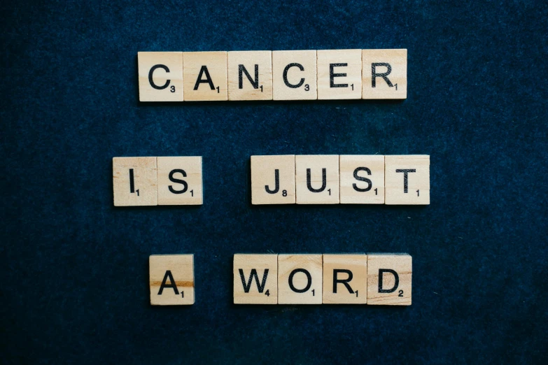 wooden scrabbles spelling cancer is just a word, pexels contest winner, biological photo, ad image, fan favorite, a dark