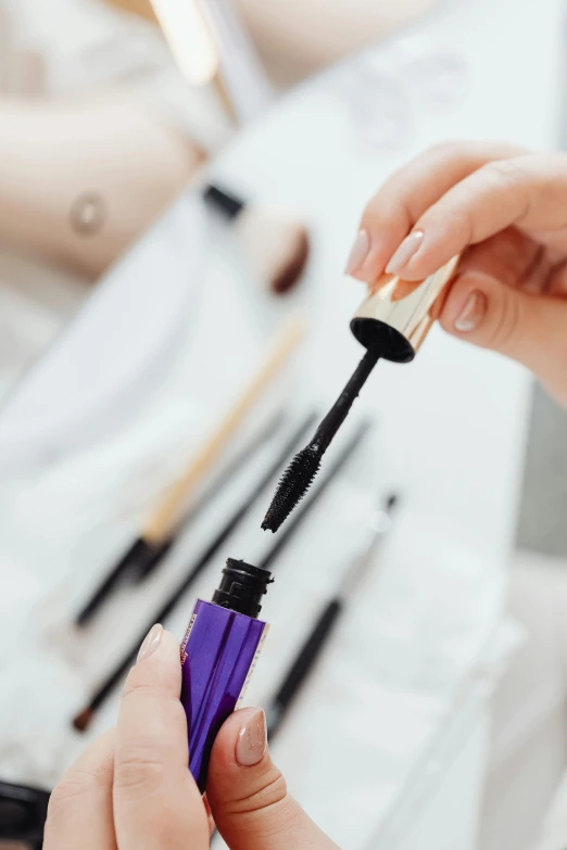 a close up of a person holding a mascara brush, violet and black, oils, black, pristine and clean