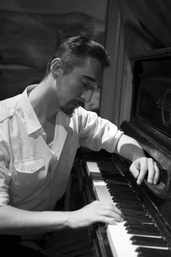 a black and white photo of a man playing a piano, inspired by Federico Zandomeneghi, reddit, happening, joe taslim, attractive man playing piano, sydney hanson, profile image