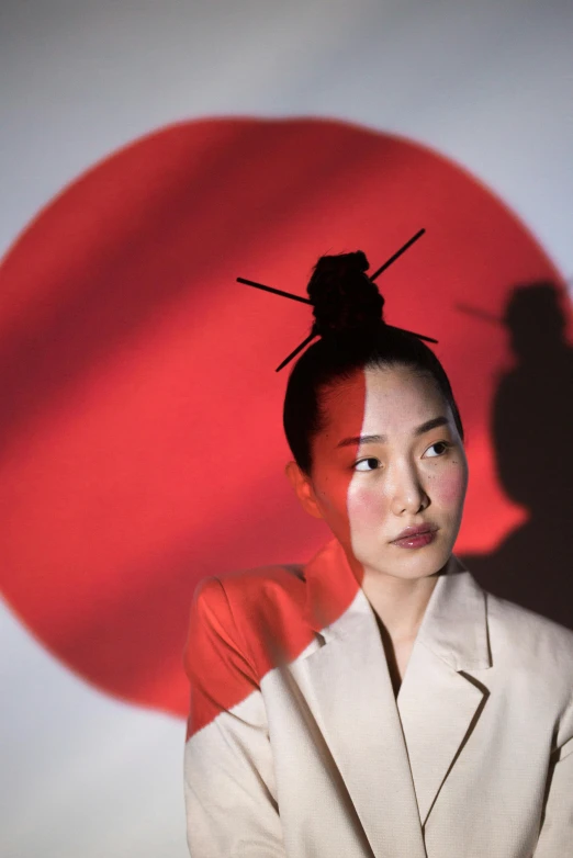 a woman standing in front of a red sun, an album cover, inspired by Taro Yamamoto, unsplash, ukiyo-e, hair styled in a bun, a portrait of issey miyake, gong li, ( ( theatrical ) )