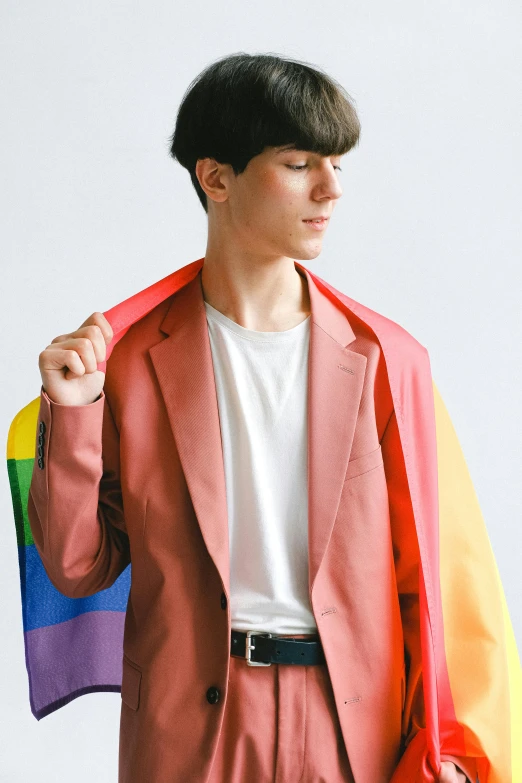 a man in a suit holding a rainbow flag, an album cover, inspired by jeonseok lee, neo-dada, wearing red jacket, teenage boy, with a white background, androgynous person