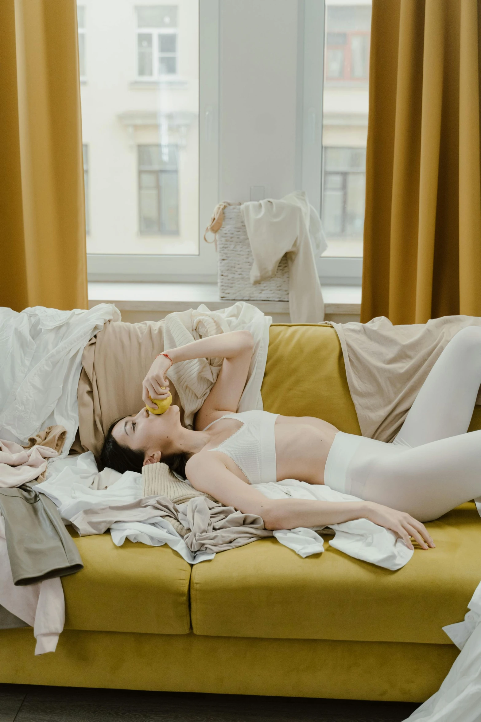 a couple of women laying on top of a couch, inspired by Sarah Lucas, pexels contest winner, messy clothes, white and yellow scheme, maxim sukharev, she is eating a peach