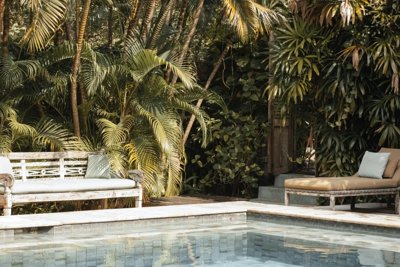 a white bench sitting next to a swimming pool, inspired by Edwin Deakin, palms, vintage vibe, sun dappled, sao paulo