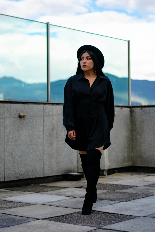 a woman in a black dress and over the knee boots, inspired by Marina Abramović, pexels contest winner, alanis guillen, portrait androgynous girl, overlooking, long shirt