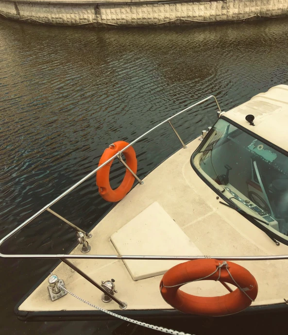 a white boat sitting on top of a body of water, cockpit view, on a boat, colour photograph, low details