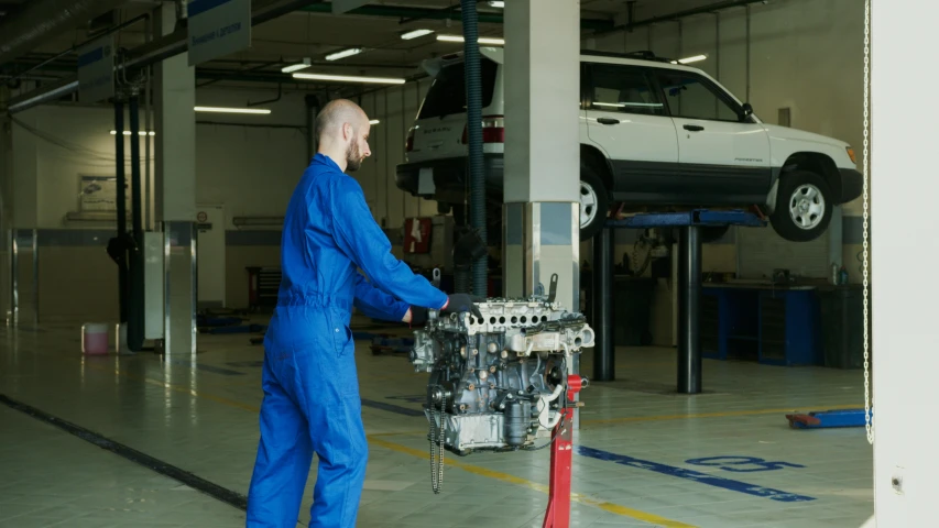 a man working on a car in a garage, a portrait, shutterstock, diesel engine, maintenance photo