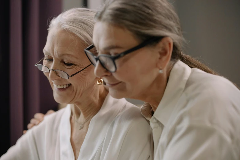 a couple of women standing next to each other, a picture, trending on pexels, an elderly, profile image, with subtitles, healthcare