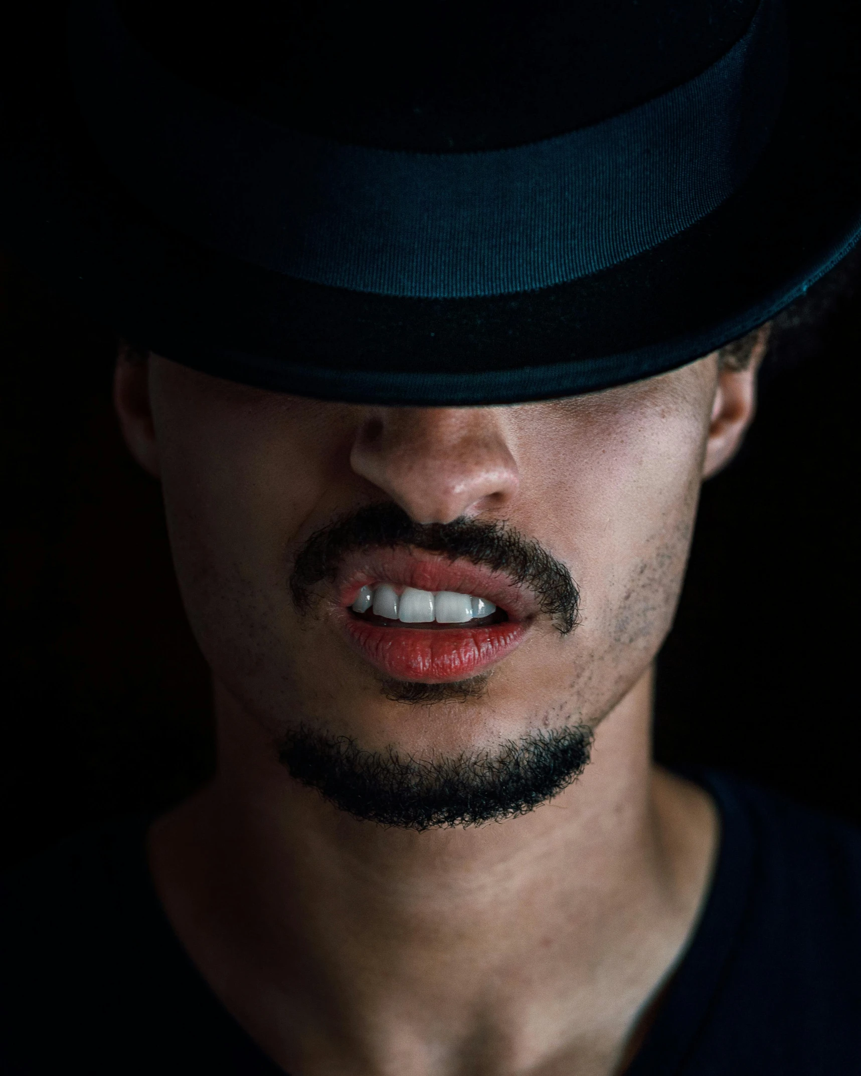 a close up of a person wearing a hat, an album cover, inspired by Hedi Xandt, pexels contest winner, antipodeans, short goatee, mixed race, androgynous vampire, mouth slightly open