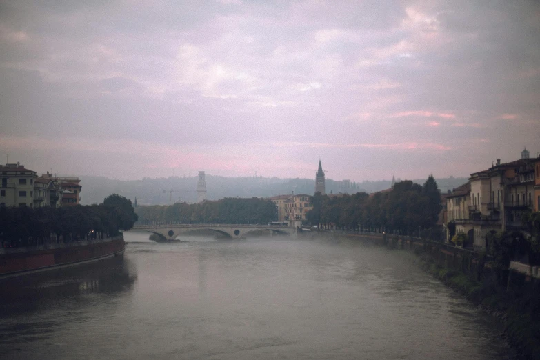 a river running through a city under a cloudy sky, pexels contest winner, tonalism, light pink mist, morandi, medium format, overcast dusk