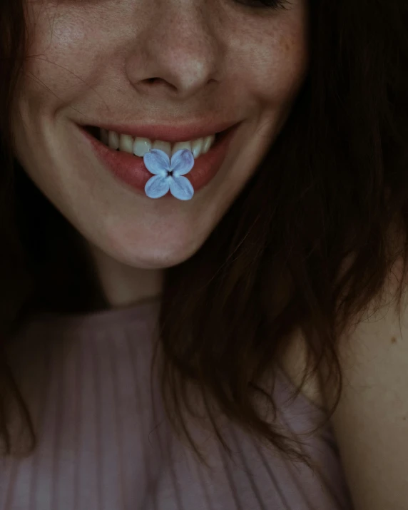 a close up of a person with a flower in her mouth, smileeeeeee, blueish