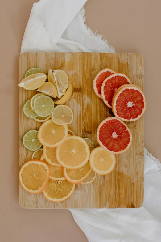 a cutting board topped with sliced oranges and limes, by Kristin Nelson, various colors, mid shot