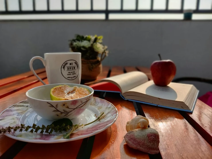 a cup of coffee sitting on top of a wooden table, plates of fruit, reading, after the rain, sakimichan