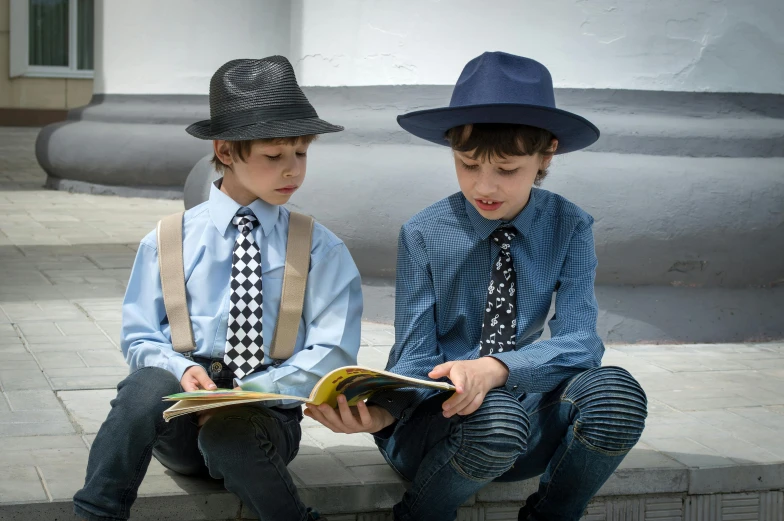 a couple of young boys sitting next to each other, an album cover, by Joe Bowler, pexels, blue fedora, school uniform, reading new book, wearing a shirt with a tie