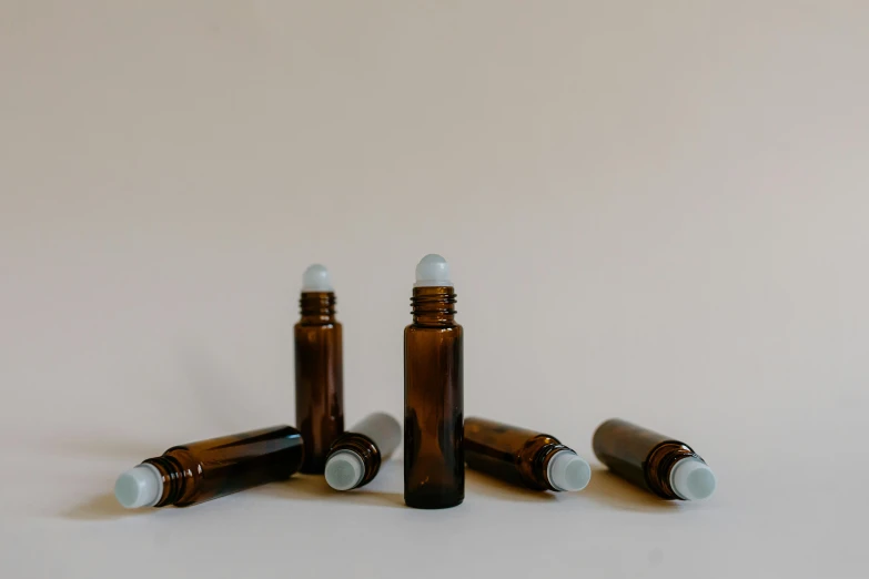 three empty brown glass bottles on a white surface, unsplash, healing tubes, 6 pack, miniature product photo, jenna barton