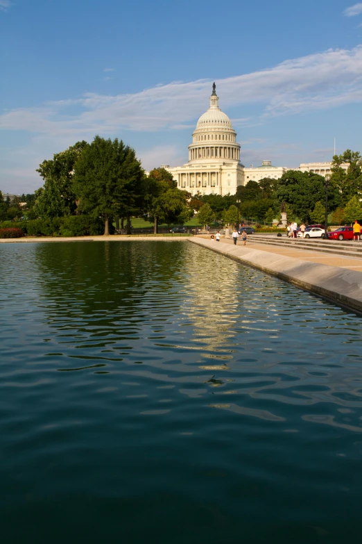 a body of water with a building in the background, capitol hill, capital plaza, marble reflexes, beautiful surroundings