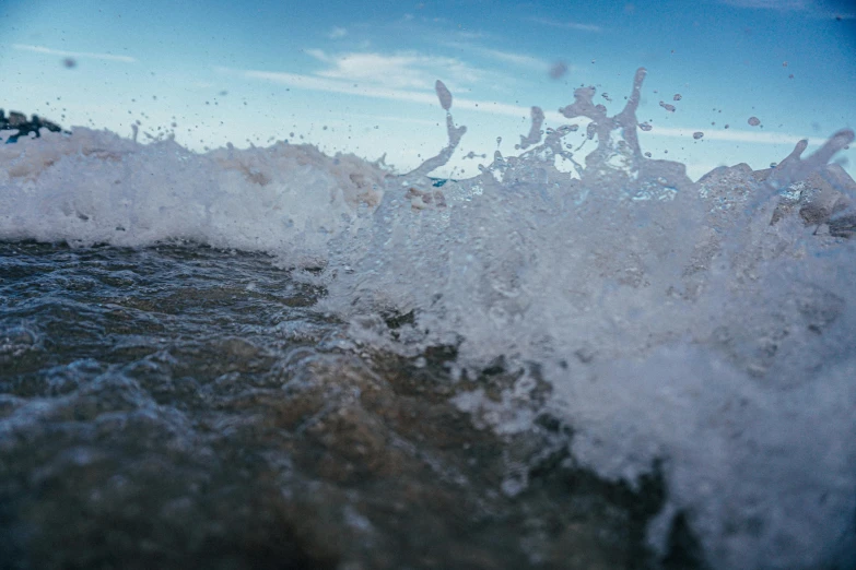 a man riding a wave on top of a surfboard, an album cover, unsplash, wave of water particles, frozen sea, a close-up, shoreline