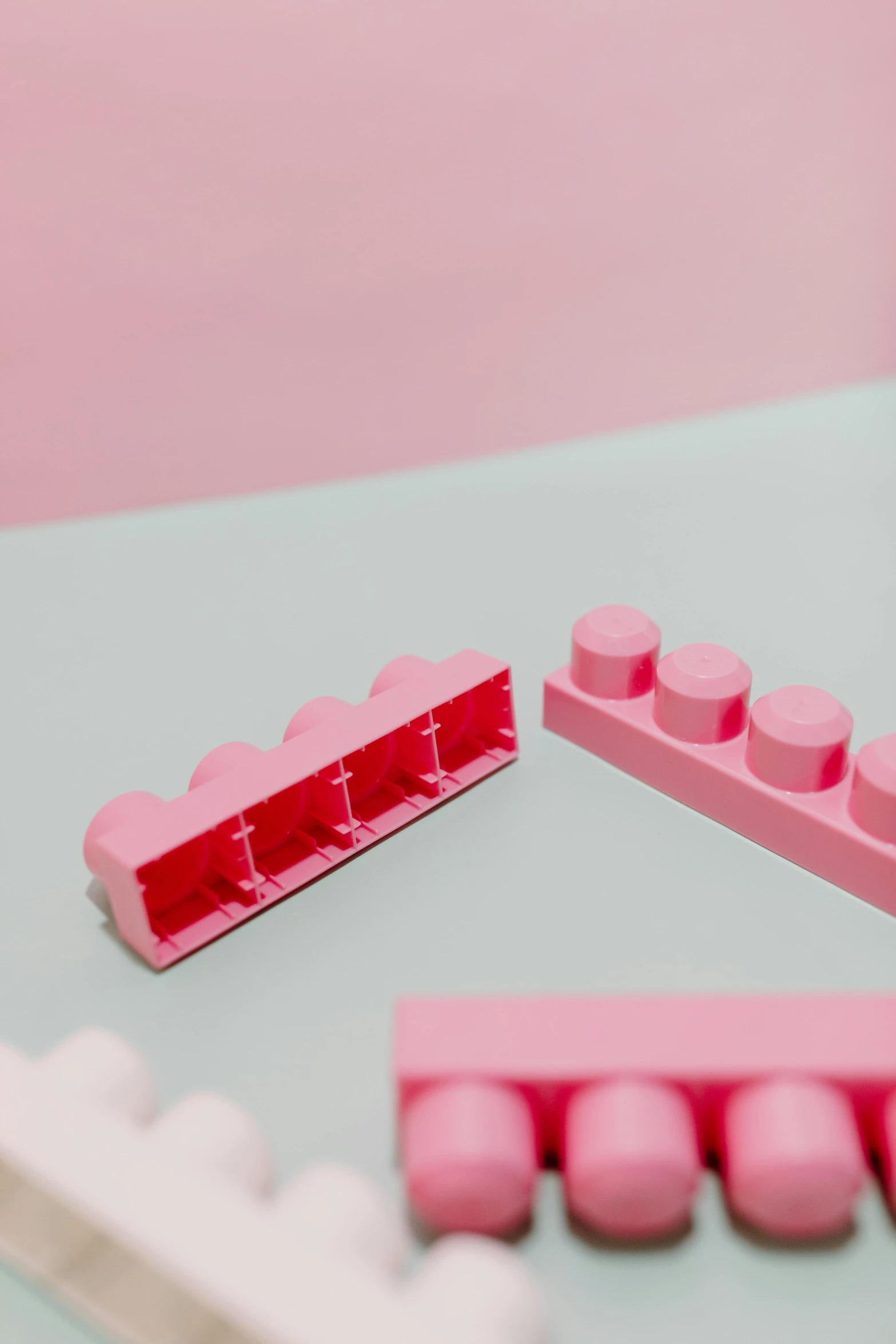 a couple of pink legos sitting on top of a table, pexels contest winner, plasticien, soft aesthetic, pink scheme, contracept, set pieces