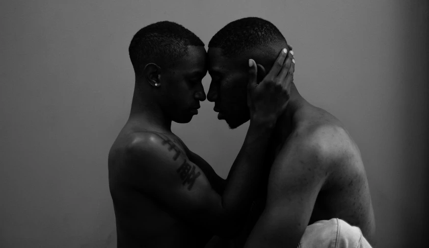 a couple of men standing next to each other, a black and white photo, by Alasdair Grant Taylor, holding each other, black main color, facing each other, multiple stories