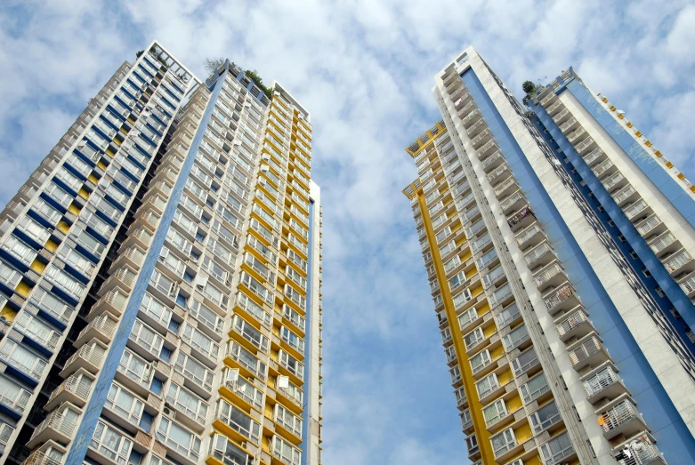 a couple of tall buildings next to each other, inspired by Cheng Jiasui, unsplash, bauhaus, residential area, golden towers, a colorful, dramatic ”