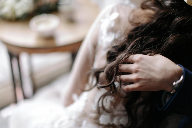 a close up of a person wearing a wedding dress, inspired by Elsa Bleda, trending on pexels, romanticism, with his hands in his hair, young woman with long dark hair, cuddling, stressing out