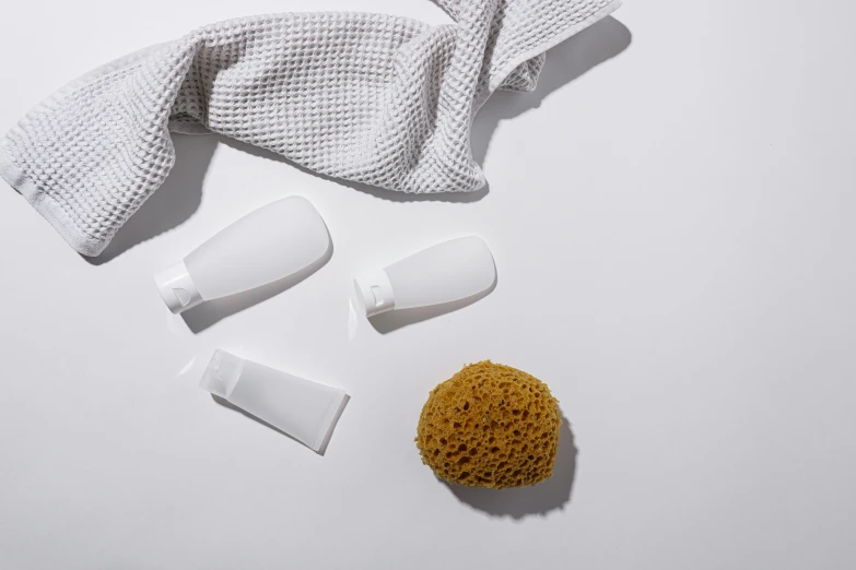 a towel, soap, and sponge on a white surface, by Carey Morris, minimalism, silicone skin, white sleeves, with textured hair and skin, fully covered