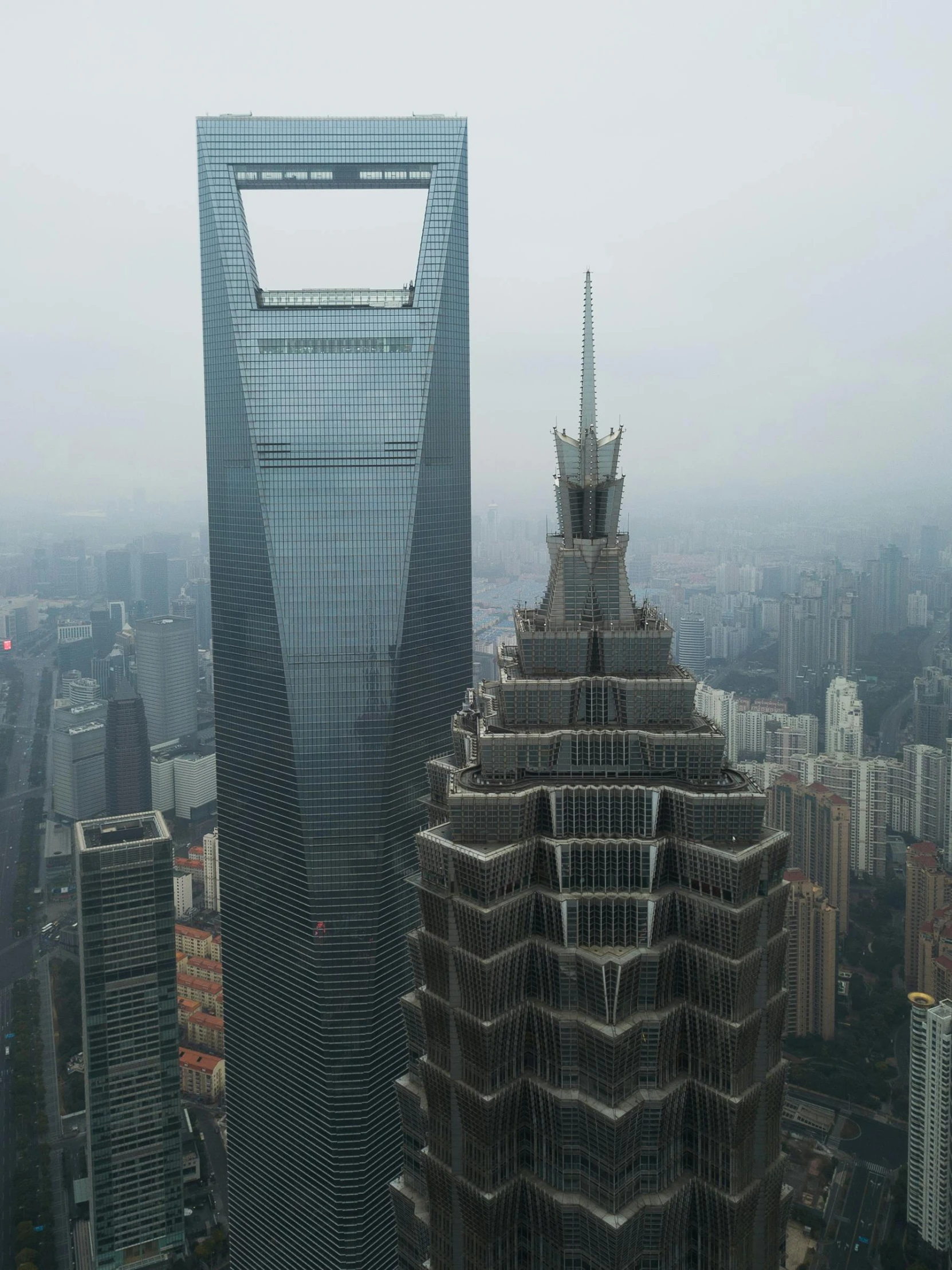 a very tall building sitting in the middle of a city, inspired by Cheng Jiasui, pexels contest winner, under a gray foggy sky, aerial, norman foster, 2 0 2 2 photo