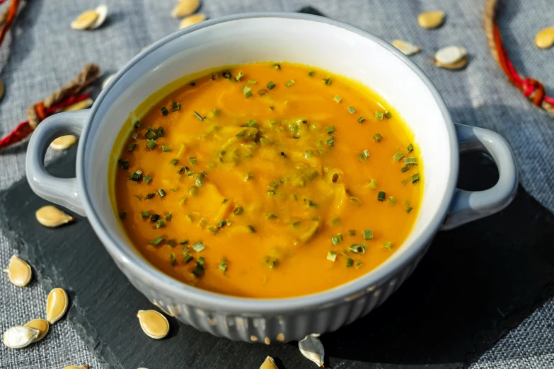 a bowl of soup sitting on top of a table, profile image, pumpkin, product image, close up image