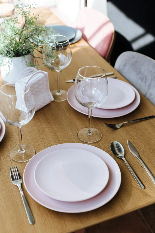 a wooden table topped with pink plates and silverware, sitting on a table, unbeatable quality, platinum, aura