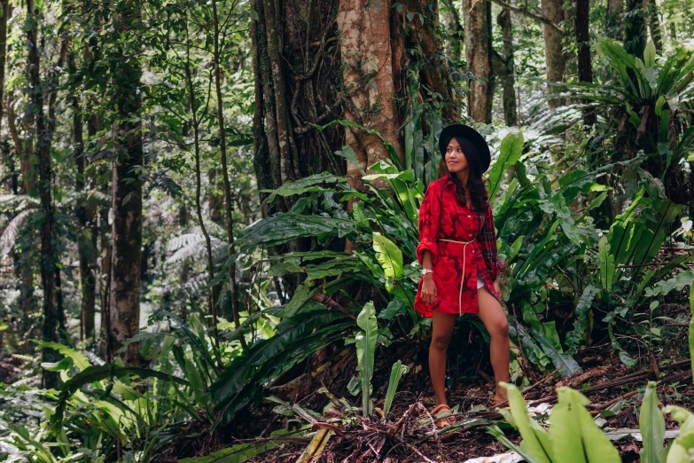 a woman standing in the middle of a forest, a portrait, by Julia Pishtar, sumatraism, wearing a red outfit, tropical style, in australia, avatar image