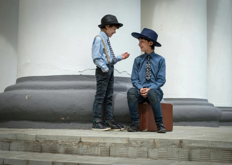 a couple of young boys standing next to each other, by Emma Andijewska, pexels contest winner, quito school, a suited man in a hat, at high noon, ukrainian, cinema still