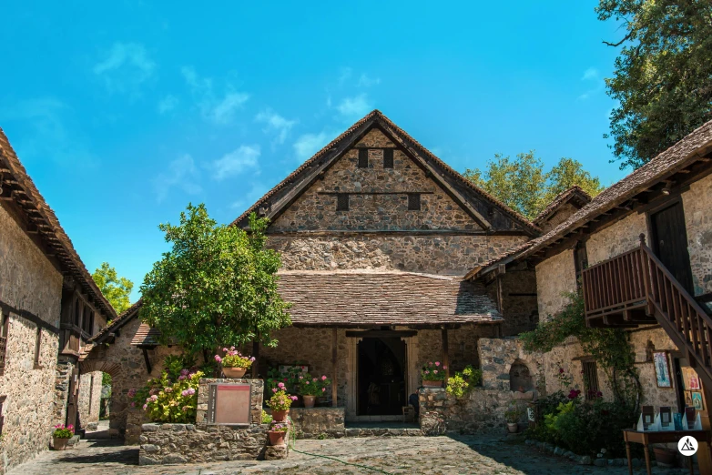 a stone building sitting in the middle of a cobblestone street, inspired by Rudolf Ernst, pexels contest winner, romanesque, in karuizawa, philippines, sunny day time, medieval tavern