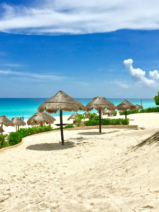 a group of umbrellas sitting on top of a sandy beach