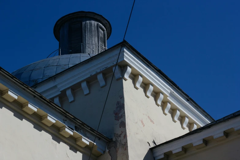 a clock that is on the side of a building, an album cover, by Attila Meszlenyi, neoclassicism, pointy conical hat, фото девушка курит, ventilation shafts, blue sky