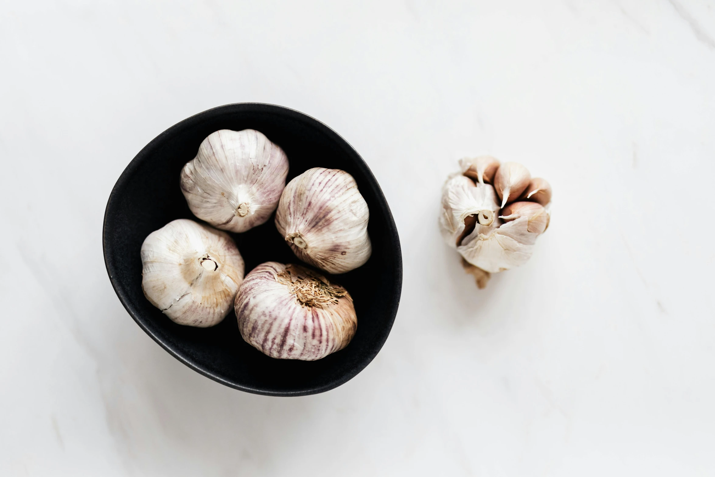 a bowl of garlic next to a clove of garlic, trending on unsplash, grey vegetables, epicurious, 2000s photo, gongbi